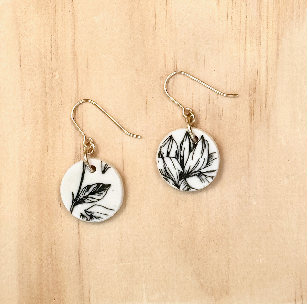 Handmade black and white porcelain Magnolia drop earrings with botanical floral design and gold-filled ear wires by Hudson Ceramics