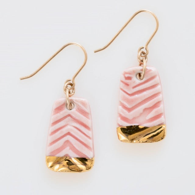 A pair of handmade porcelain earrings with gold accents and pink stripes, attached to gold-filled ear wires.