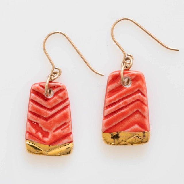 A pair of handmade porcelain earrings with gold accents and red stripes, attached to gold-filled ear wires.