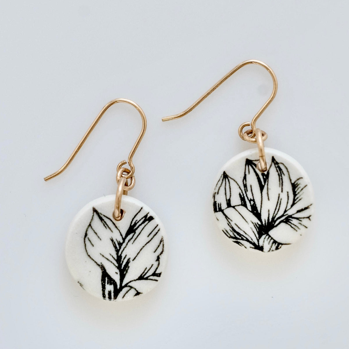 Handmade black and white porcelain Magnolia drop earrings with botanical floral design and gold-filled ear wires by Hudson Ceramics