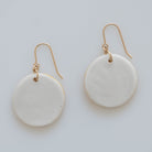 Solid white back view of circular floral earrings with gold ear wires