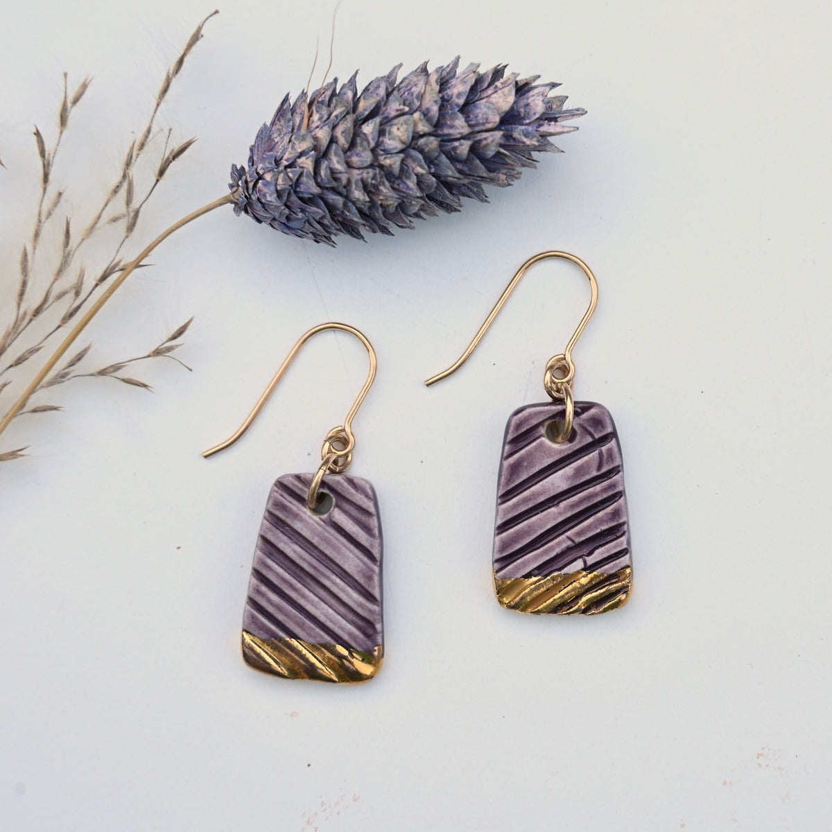 Handmade purple Willow porcelain earrings with carved diagonal texture, gold luster and gold-filled ear wires by Hudson Ceramics